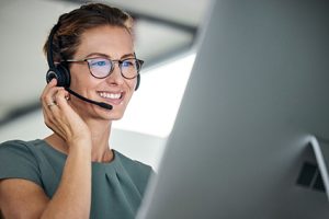 Customer service, woman and happy call center agent giving advice online using a headset. Operator, telemarketing and support with hotline consultant working for contact us help or arm consulting.